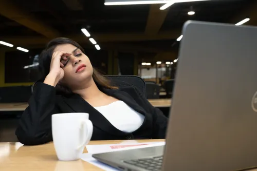A tired employee at work, representing the fatigue and exhaustion that often accompanies iron deficiency